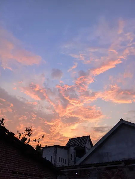 Pemandangan sunset di tengah-tengah atap rumah