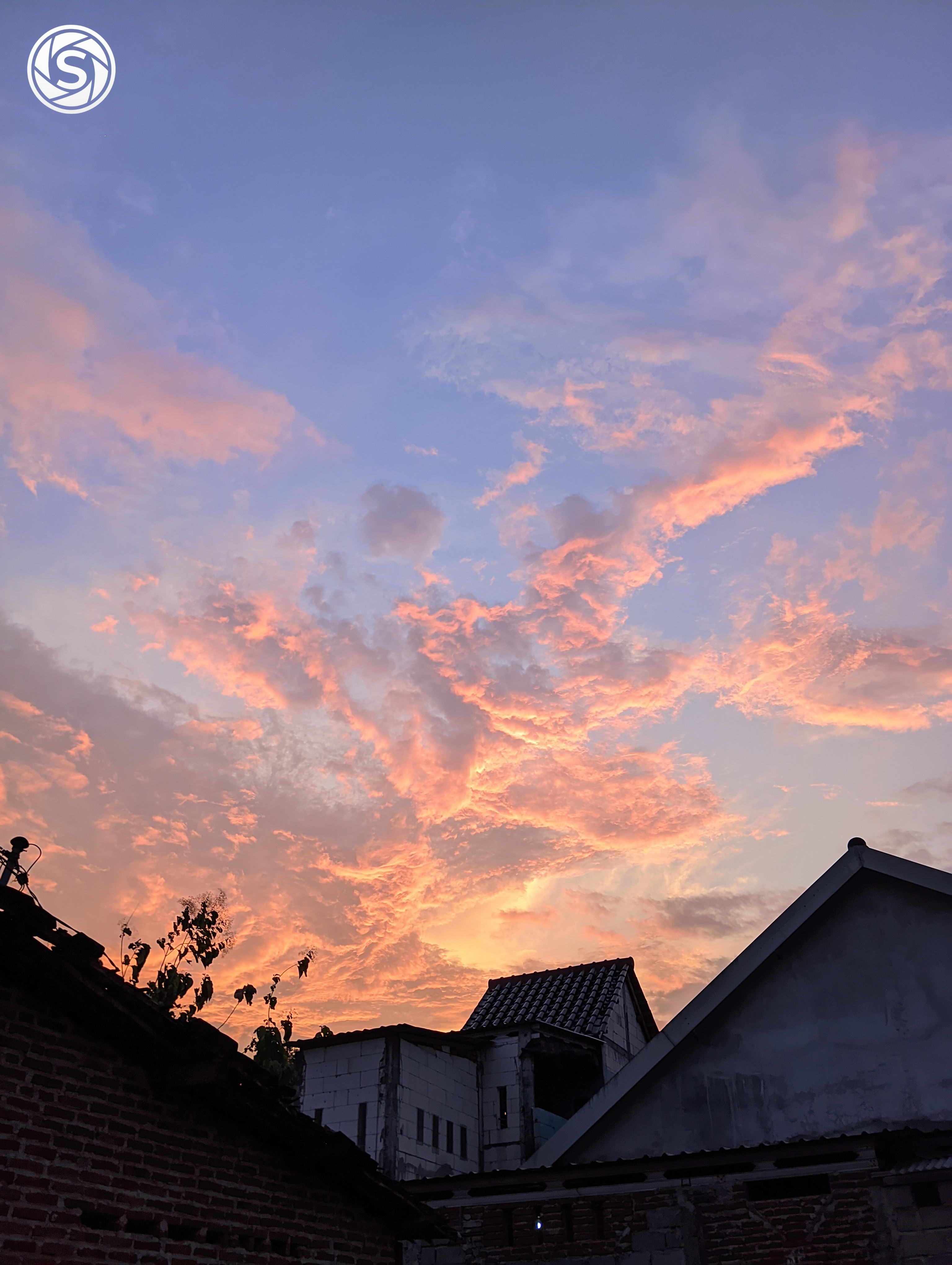Pemandangan sunset di tengah-tengah atap rumah